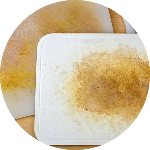 Heavily scratched and stained plastic cutting board